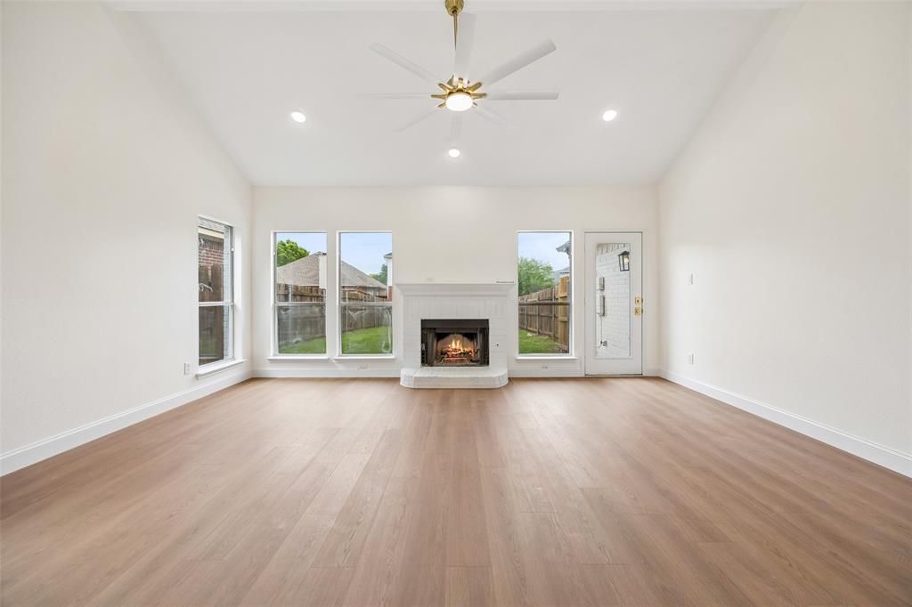 819 Kipling Drive Allen, TX 75002 - Photo 6 of 29 an empty room with wooden floor fireplace and windows