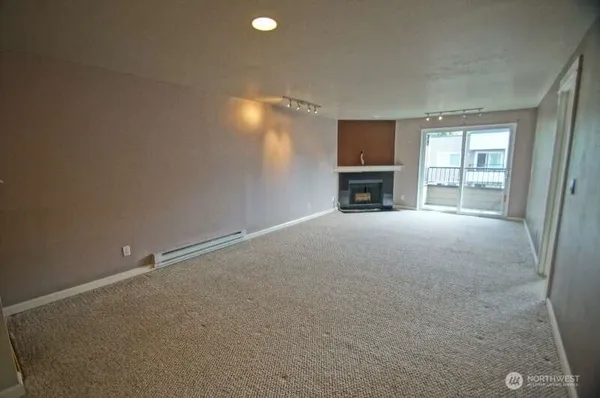 an empty room with fireplace and windows