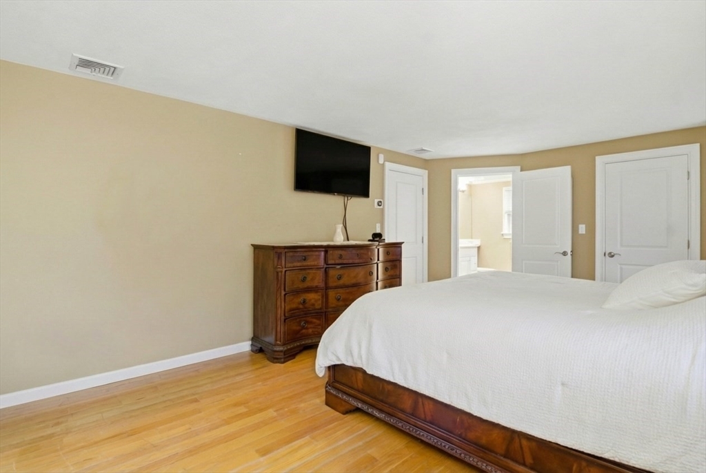 64 Browning Road Arlington, MA 02476 - Photo 11 of 25 a bedroom with a bed and a flat screen tv