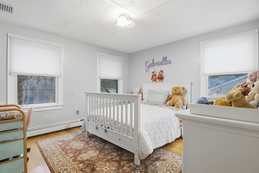64 Browning Road Arlington, MA 02476 - Photo 15 of 25 a view of a bedroom with baby bed and a window
