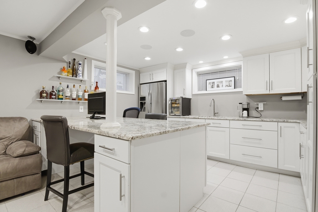 64 Browning Road Arlington, MA 02476 - Photo 18 of 25 a kitchen with granite countertop white cabinets and chairs
