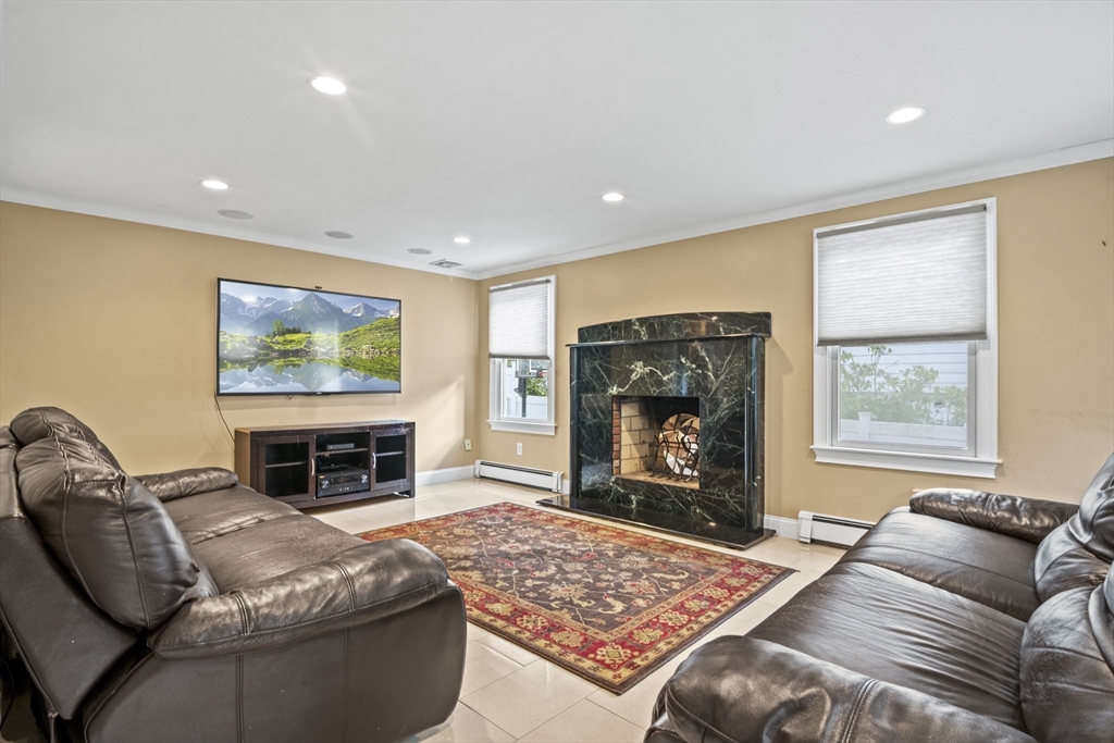 64 Browning Road Arlington, MA 02476 - Photo 7 of 25 a living room with furniture a flat screen tv and a fireplace