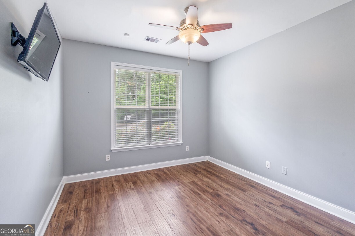 82 Newton Road LaGrange, GA 30240 - Photo 29 of 45 an empty room with wooden floor chandelier fan and windows