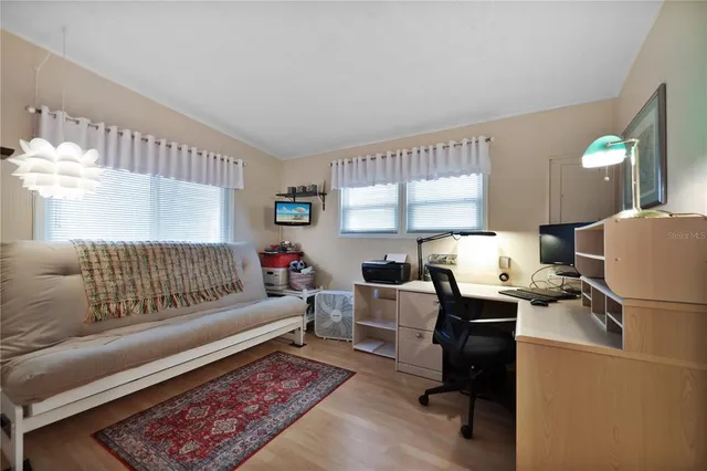 a view of a hallway with wooden floor and a bathroom