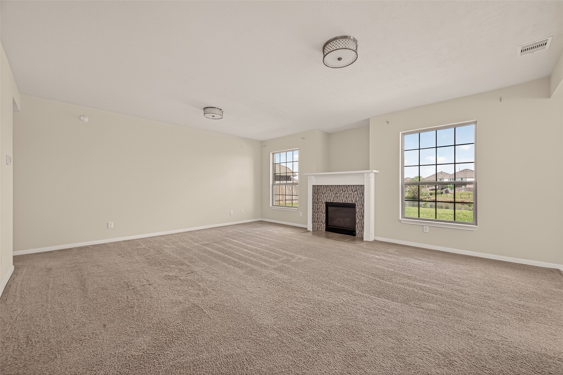 29 Palmero Way Manvel, TX 77578 - Photo 3 of 31 Spacious living room with fireplace and natural light overlooking the backyard and lake.