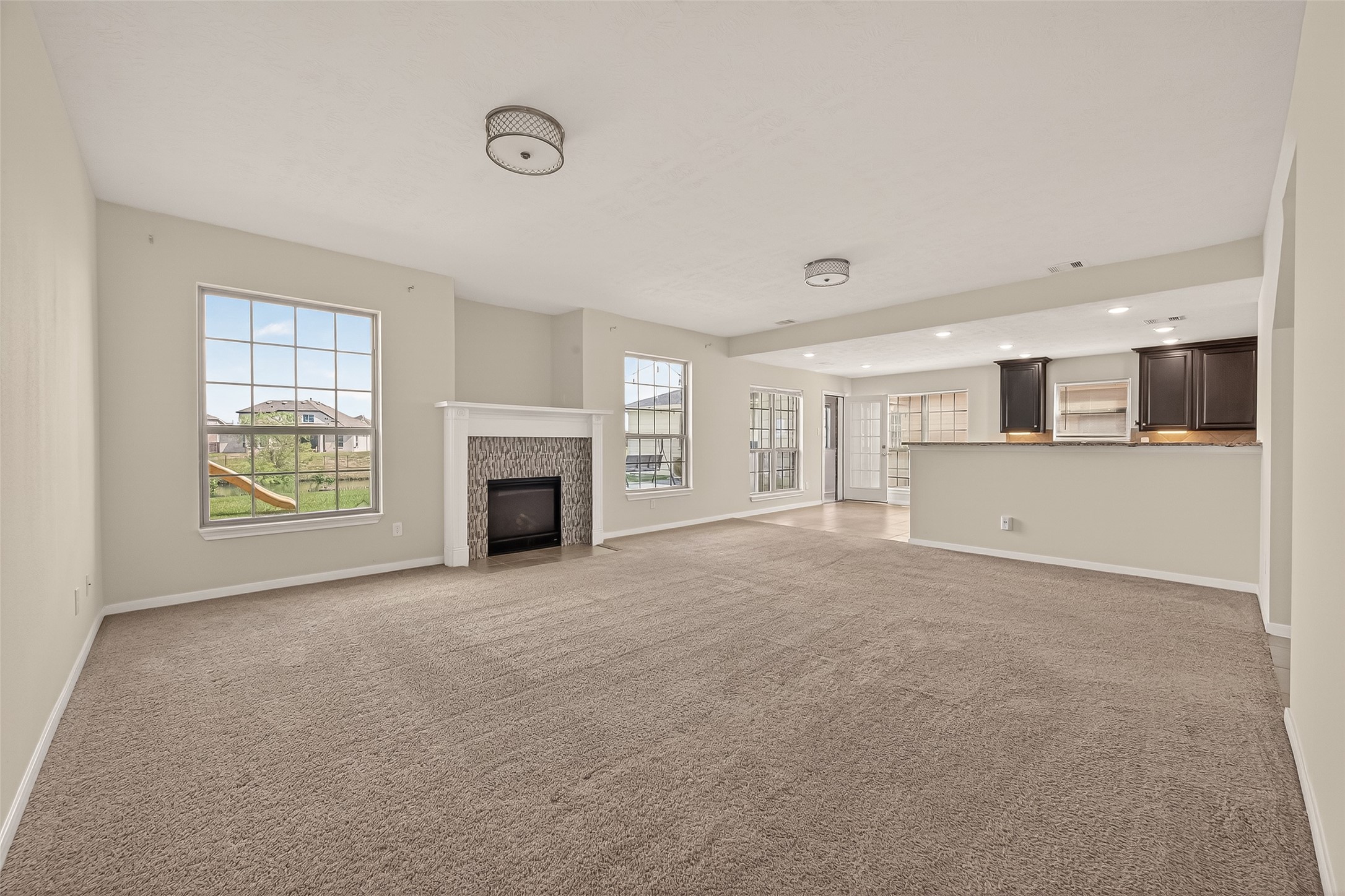 29 Palmero Way Manvel, TX 77578 - Photo 9 of 31 Open-concept living area with fireplace, seamlessly flowing into the kitchen and breakfast area.