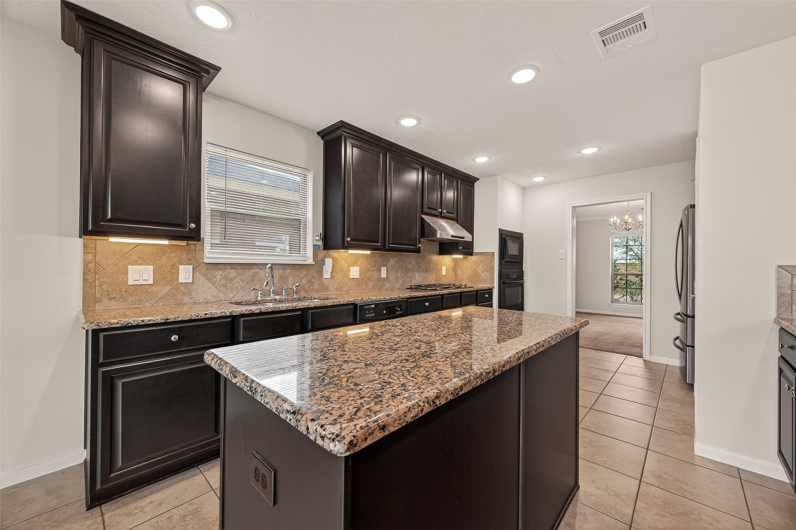 29 Palmero Way Manvel, TX 77578 - Photo 10 of 31 a kitchen with granite countertop kitchen island stainless steel appliances a sink stove and oven