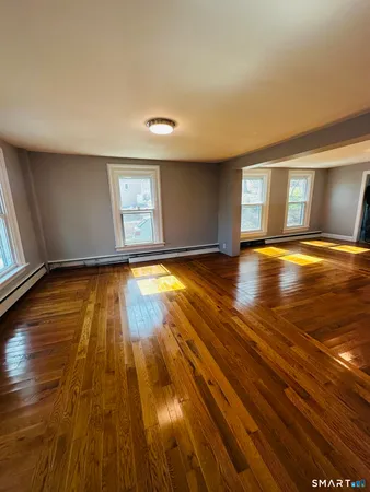 a view of empty room with window and wooden floor