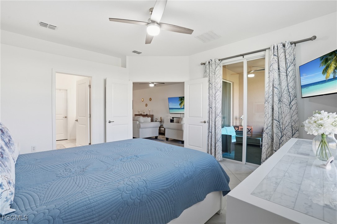 2617 Vine Avenue Naples, FL 34120 - Photo 18 of 27 a bedroom with a bed and a chandelier