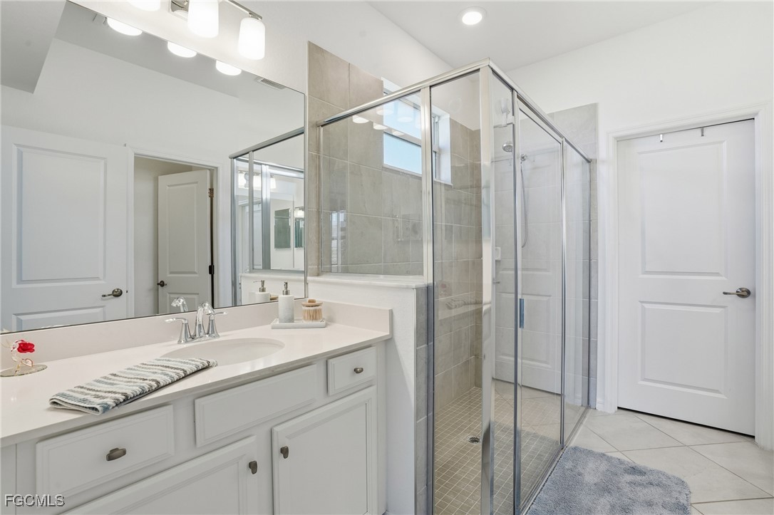 2617 Vine Avenue Naples, FL 34120 - Photo 19 of 27 a bathroom with a shower sink and mirror