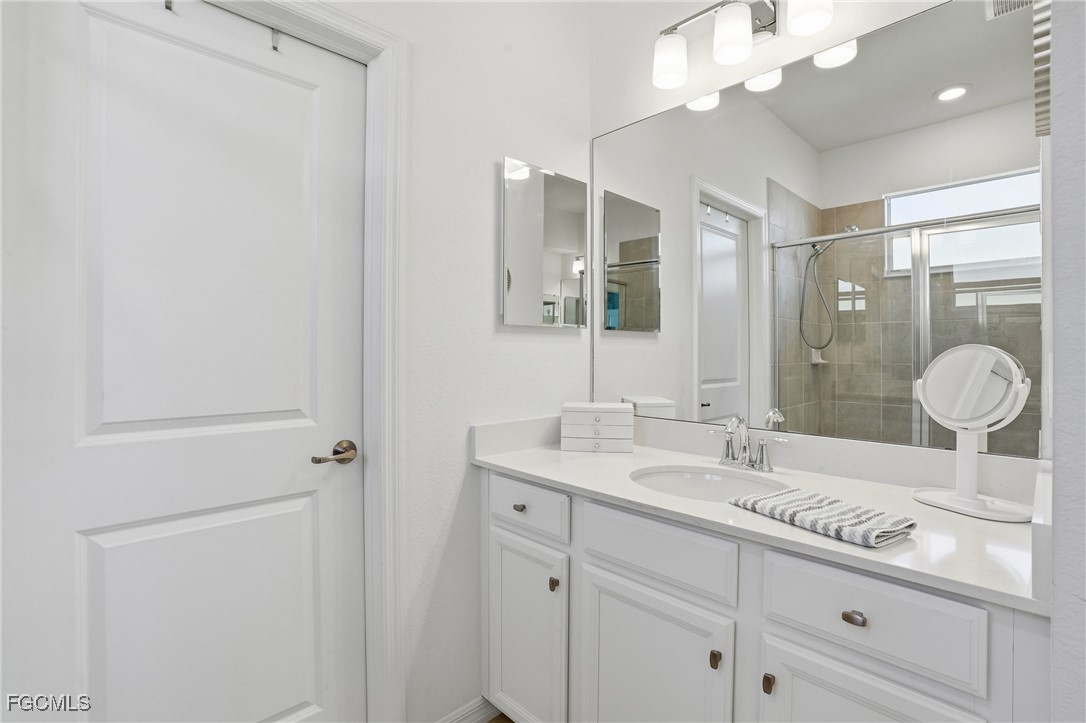 2617 Vine Avenue Naples, FL 34120 - Photo 20 of 27 a bathroom with a granite countertop sink a toilet and a mirror