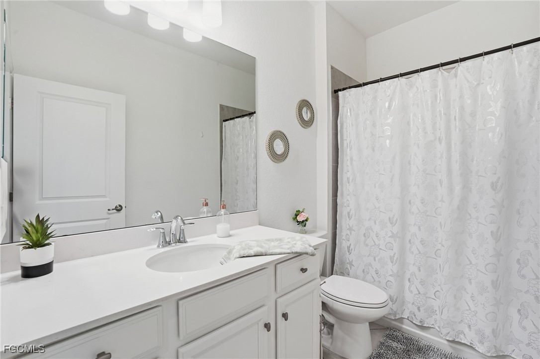 2617 Vine Avenue Naples, FL 34120 - Photo 24 of 27 a bathroom with a toilet sink and mirror