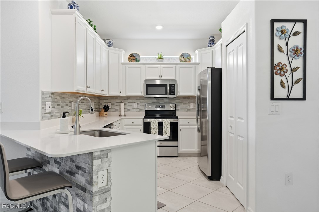 2617 Vine Avenue Naples, FL 34120 - Photo 4 of 27 a kitchen with stainless steel appliances granite countertop a refrigerator and a stove top oven