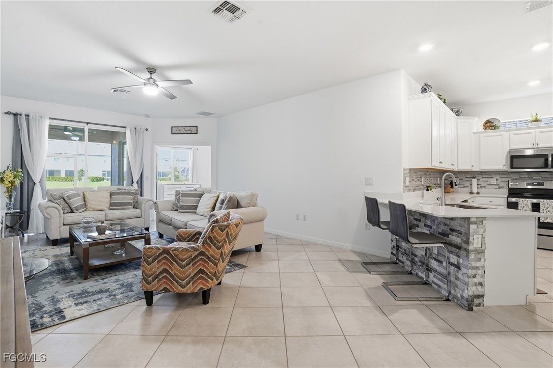 2617 Vine Avenue Naples, FL 34120 - Photo 8 of 27 a living room with furniture and a open kitchen view