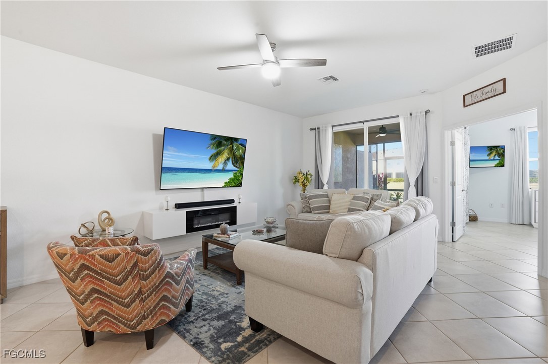 2617 Vine Avenue Naples, FL 34120 - Photo 9 of 27 a living room with furniture a ceiling fan and a flat screen tv