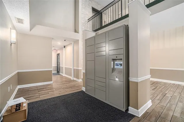 a view of a hallway with wooden floor and cabinet