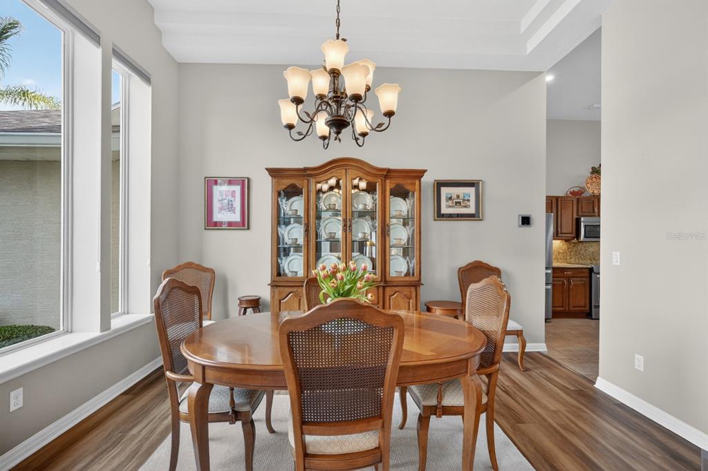 1269 Harwick Lane Ormond Beach, FL 32174 - Photo 8 of 39 a view of a dining room with furniture a chandelier and wooden floor