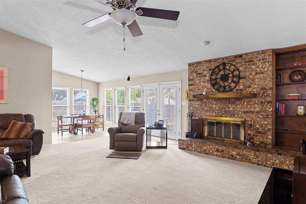 The living room features a wood-burning fireplace, and built-in shelving. 