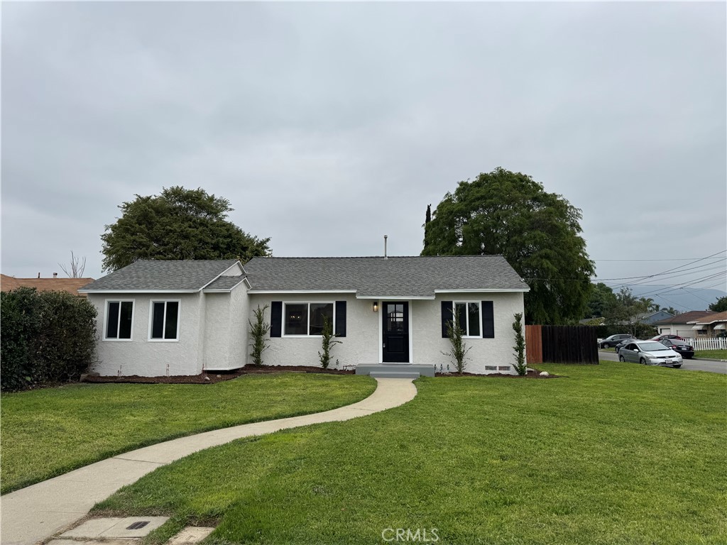 a front view of a house with a garden and trees
