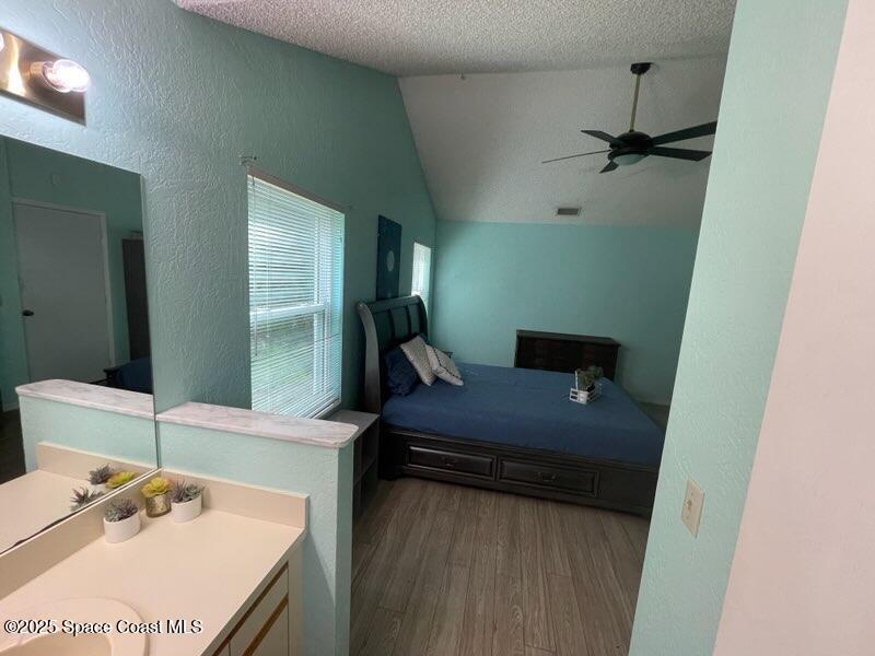 906 Black Pine Court Rockledge, FL 32955 - Photo 11 of 27 a bedroom with a bed and a mirror