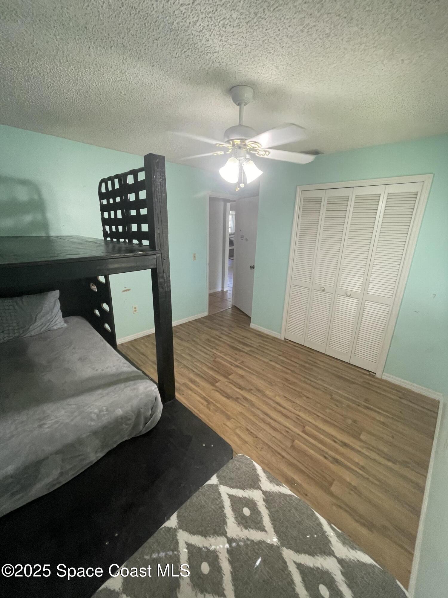 906 Black Pine Court Rockledge, FL 32955 - Photo 13 of 27 a bedroom with a bed and a chandelier