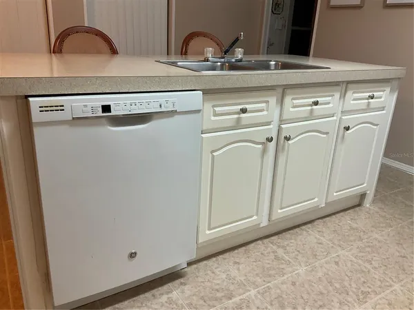 a kitchen with granite countertop white cabinets and white appliances