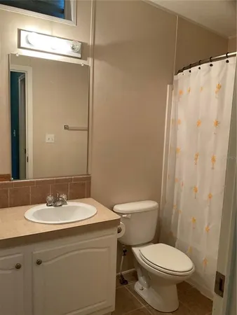 a bathroom with a sink toilet and mirror