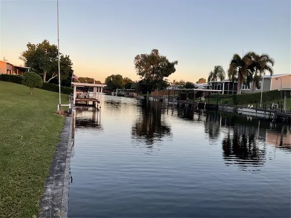 a lake view with boat and palm trees