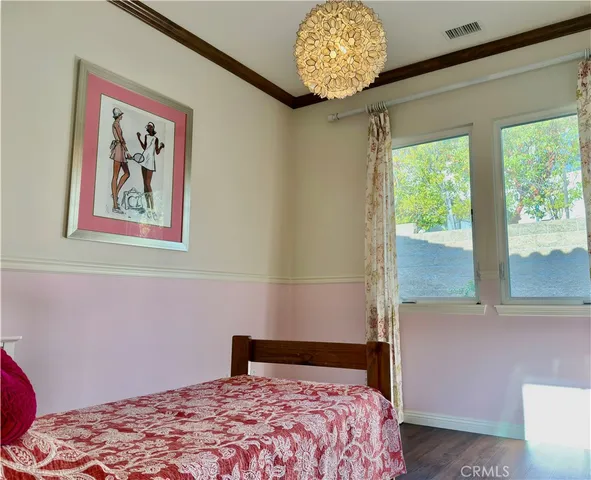 a bedroom with a bed and a painting on the wall