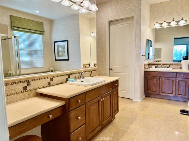 a bathroom with a sink double vanity granite tub shower and a mirror