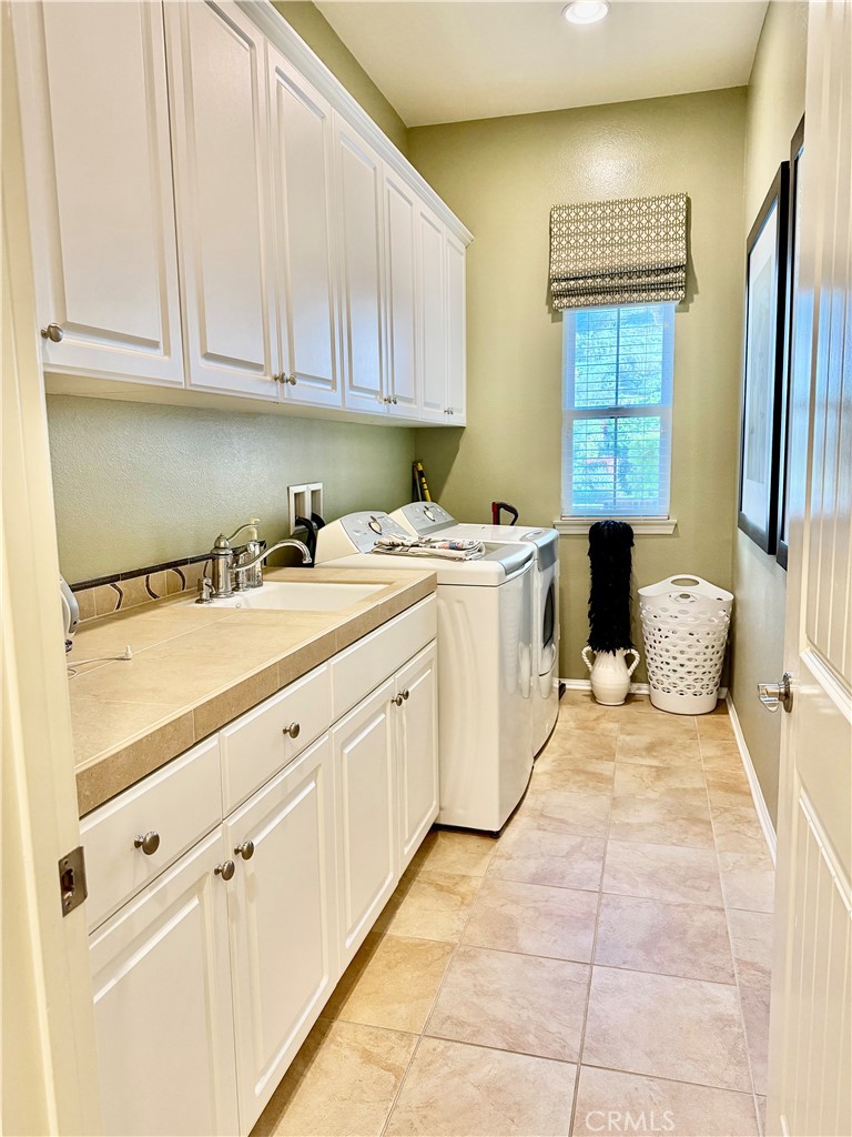 20318 West Vía Urbino Porter Ranch, CA 91326 - Photo 23 of 34 a kitchen with a sink dishwasher stove and cabinets