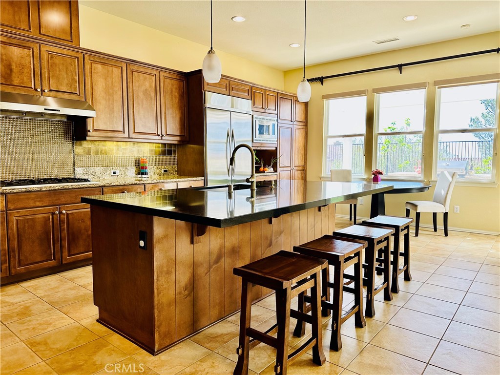20318 West Vía Urbino Porter Ranch, CA 91326 - Photo 9 of 34 a kitchen with stainless steel appliances granite countertop a sink a stove counter space and cabinets