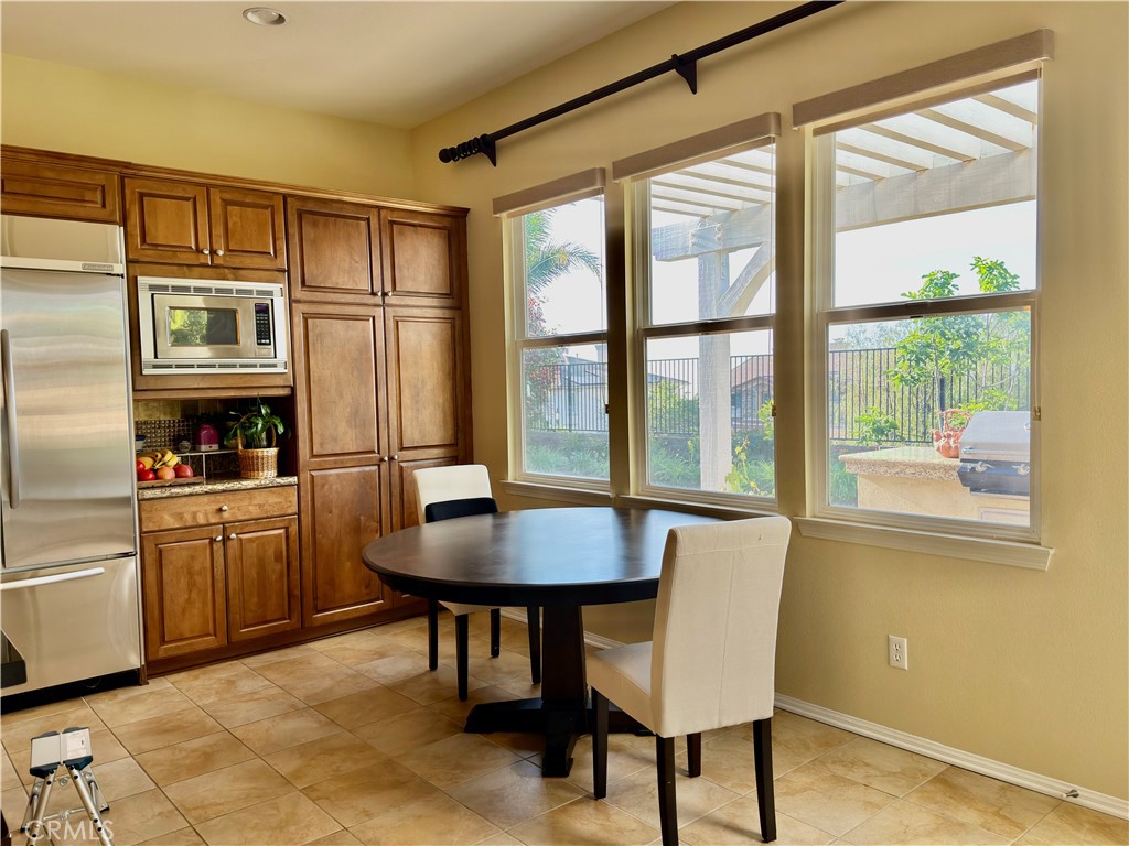 20318 West Vía Urbino Porter Ranch, CA 91326 - Photo 10 of 34 a kitchen with a table chairs refrigerator and cabinets