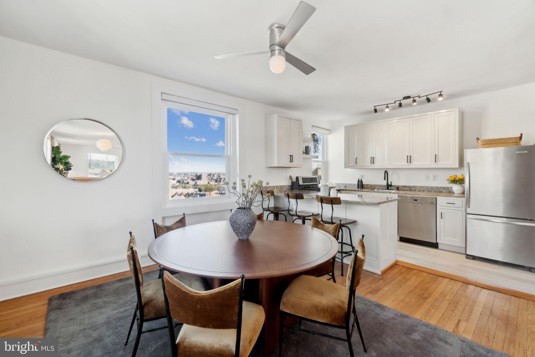 1901 Columbia Road Northwest, Unit 805 Washington, DC 20009 - Photo 11 of 37 a kitchen with a dining table chairs and refrigerator