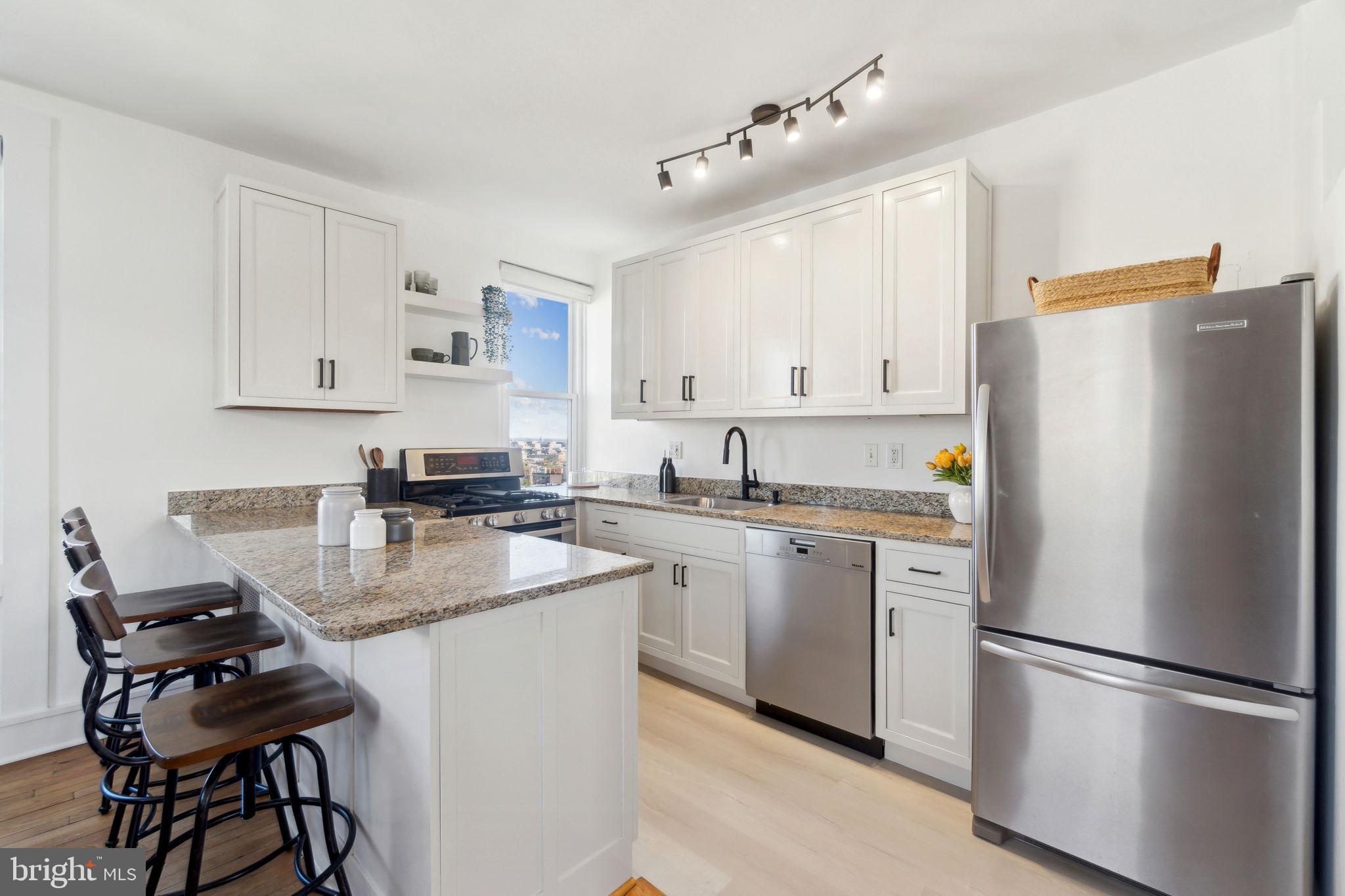 1901 Columbia Road Northwest, Unit 805 Washington, DC 20009 - Photo 12 of 37 a kitchen with refrigerator and white cabinets