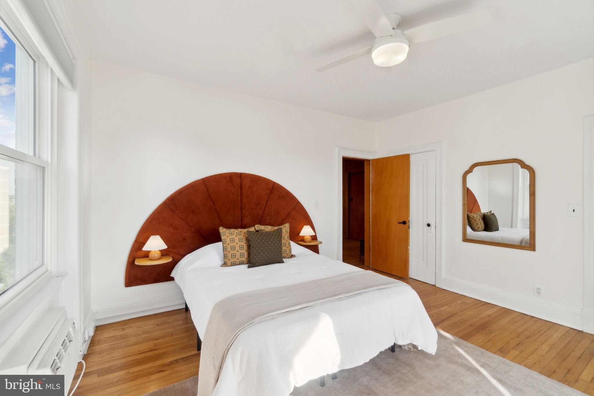 1901 Columbia Road Northwest, Unit 805 Washington, DC 20009 - Photo 20 of 37 a bedroom with a bed and a dresser with mirror