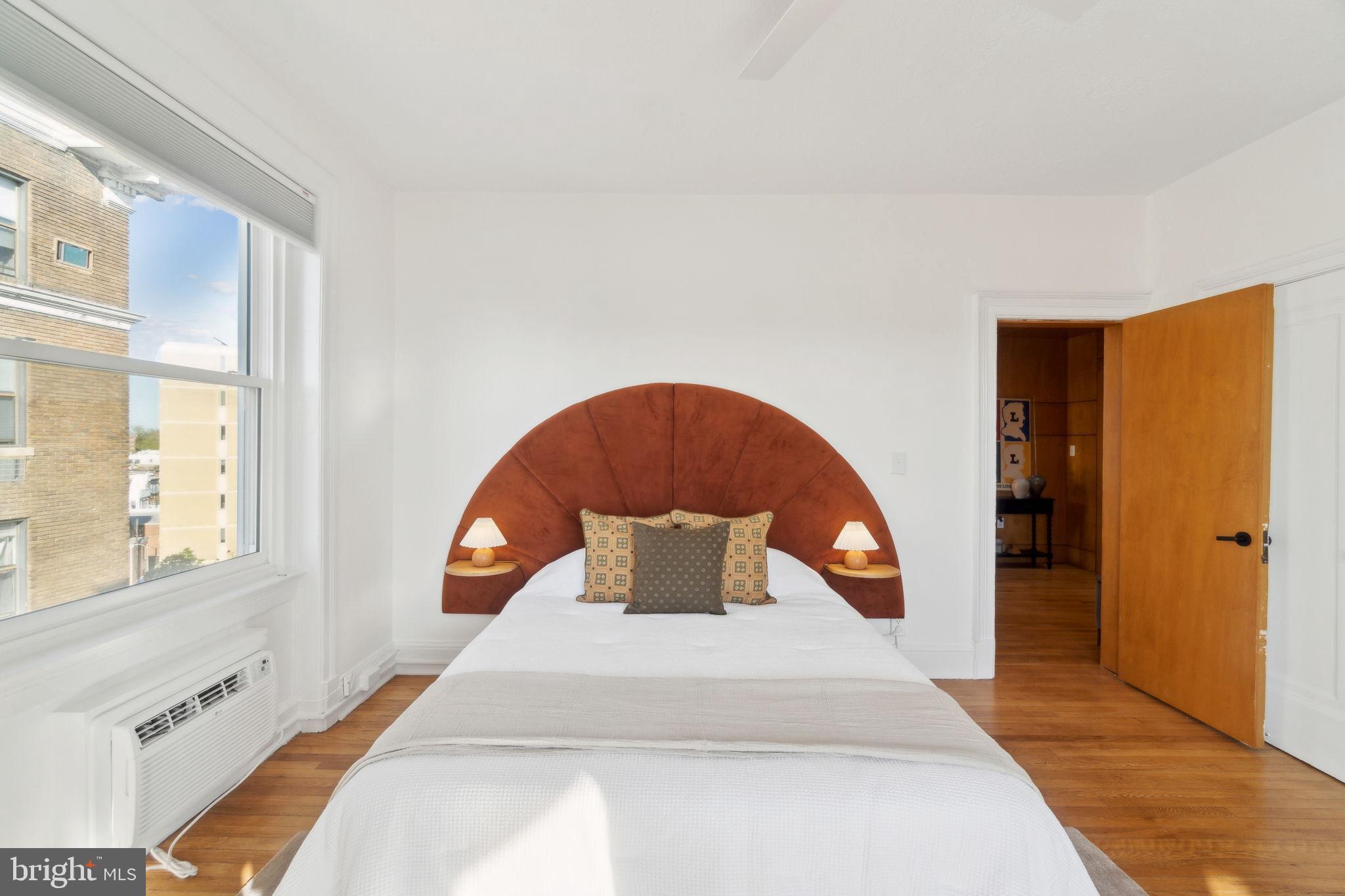 1901 Columbia Road Northwest, Unit 805 Washington, DC 20009 - Photo 21 of 37 a bedroom with a large bed and a large window