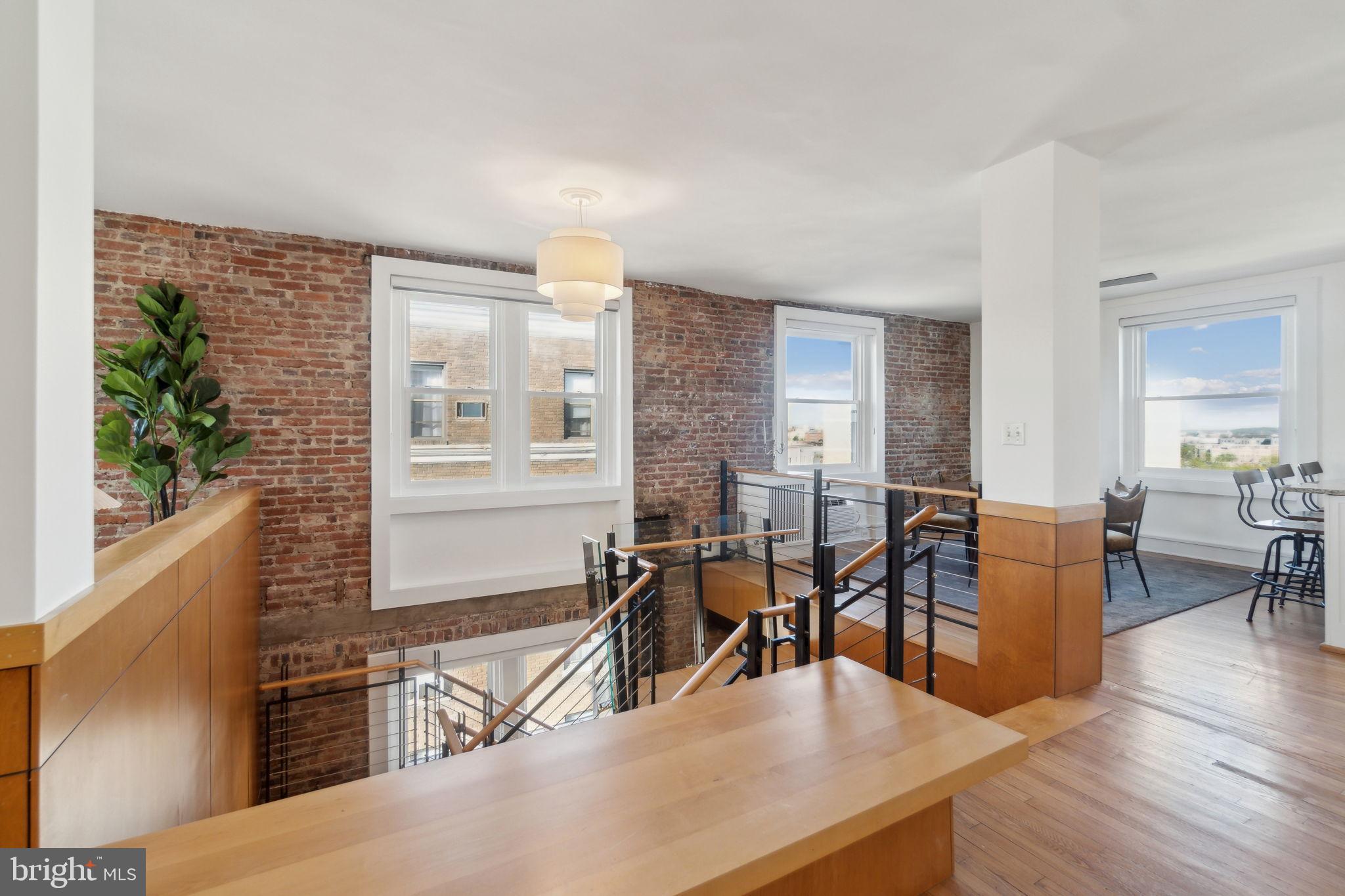 1901 Columbia Road Northwest, Unit 805 Washington, DC 20009 - Photo 3 of 37 a living room with couches a dining table and chairs with wooden floor