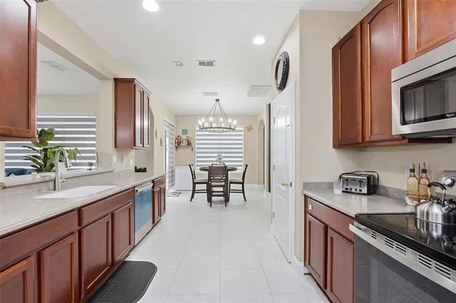 a kitchen with stainless steel appliances granite countertop a sink stove and cabinets