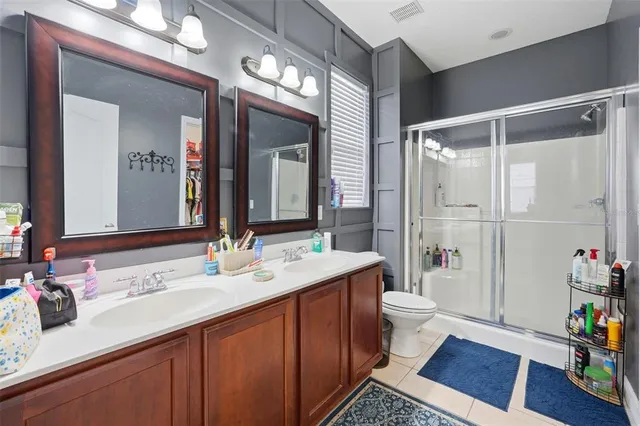 a bathroom with a sink a toilet a mirror and shower