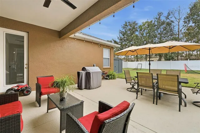 a view of a patio with a dining table and chairs under an umbrella