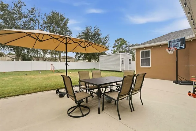 a view of a backyard with swimming pool and sitting area