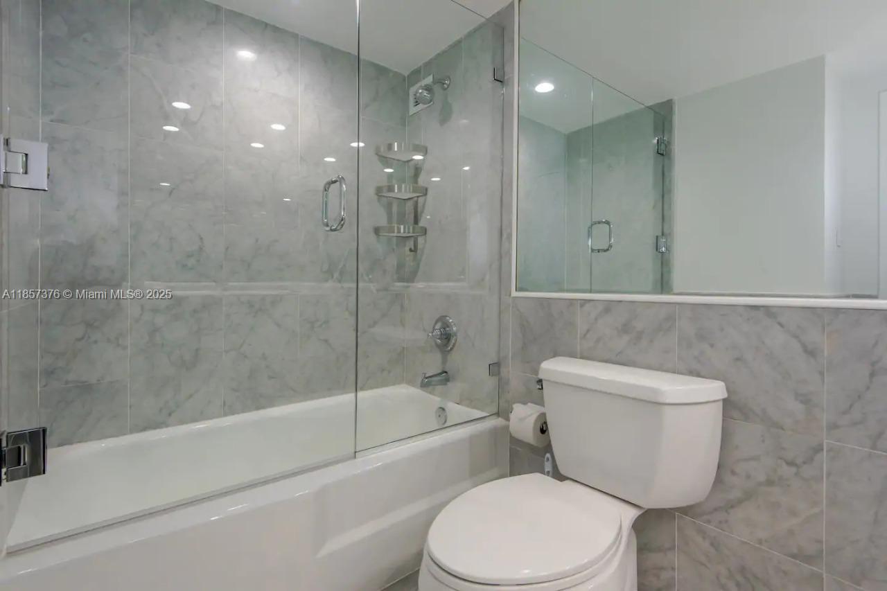 5161 Collins Avenue, Unit 1104 Miami Beach, FL 33140 - Photo 4 of 19 a bathroom with a toilet and a bathtub