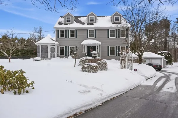 a front view of a house with yard covered in snow