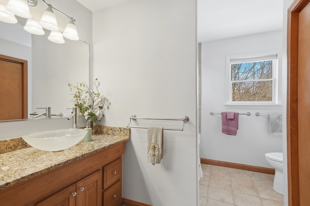 459 North Street Georgetown, MA 01833 - Photo 17 of 42 a bathroom with a granite countertop sink a mirror and vanity