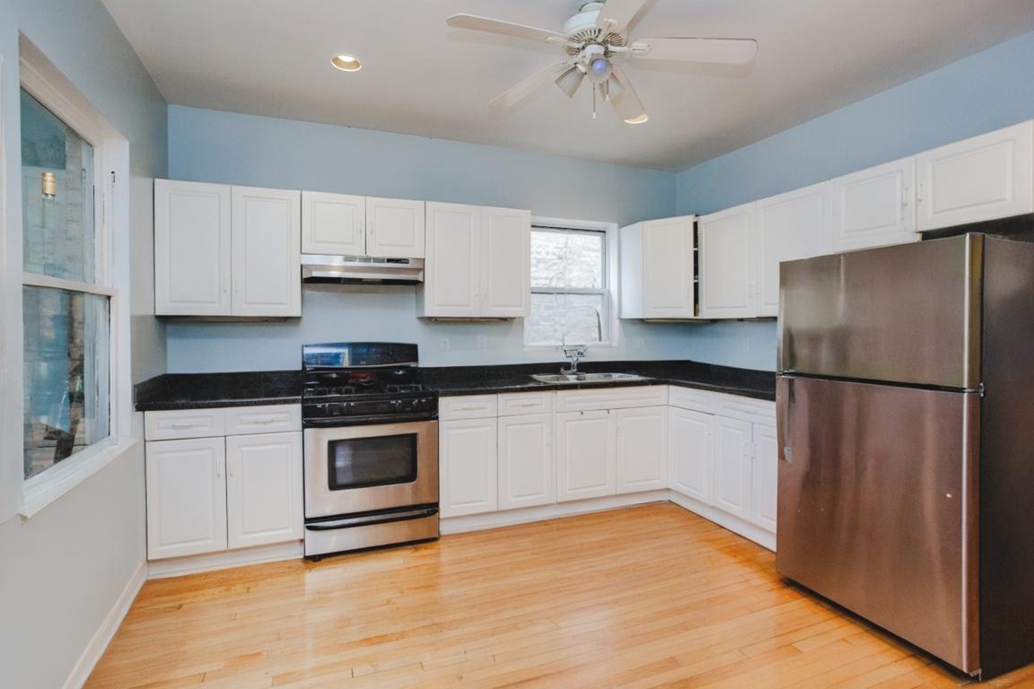 2453 North Tripp Avenue Chicago, IL 60639 - Photo 7 of 17 a kitchen with a refrigerator and white cabinets