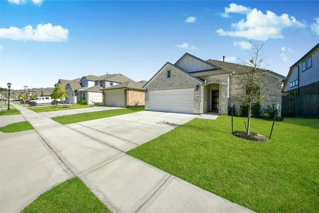 a view of a house with a big yard and large trees