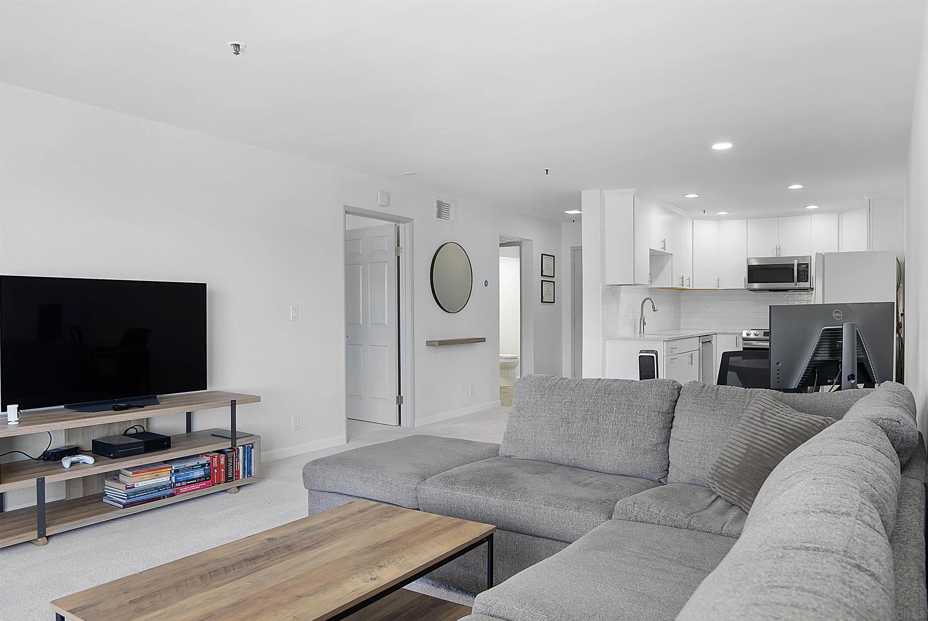 5605 Friars Road, Unit 304 San Diego, CA 92110 - Photo 6 of 37 a living room with furniture and a flat screen tv