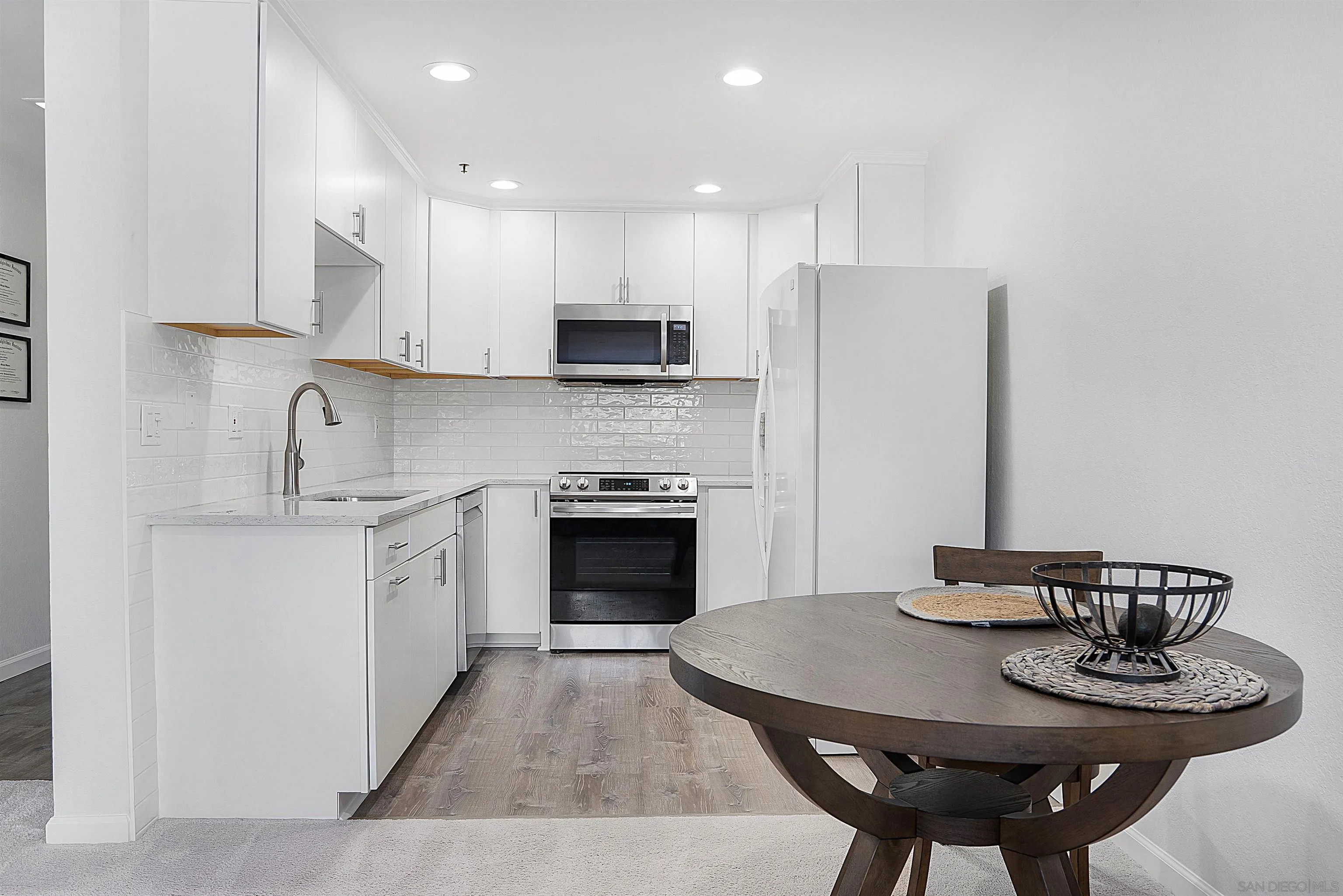 5605 Friars Road, Unit 304 San Diego, CA 92110 - Photo 9 of 37 a kitchen with stainless steel appliances granite countertop a sink a stove a refrigerator a microwave and cabinets