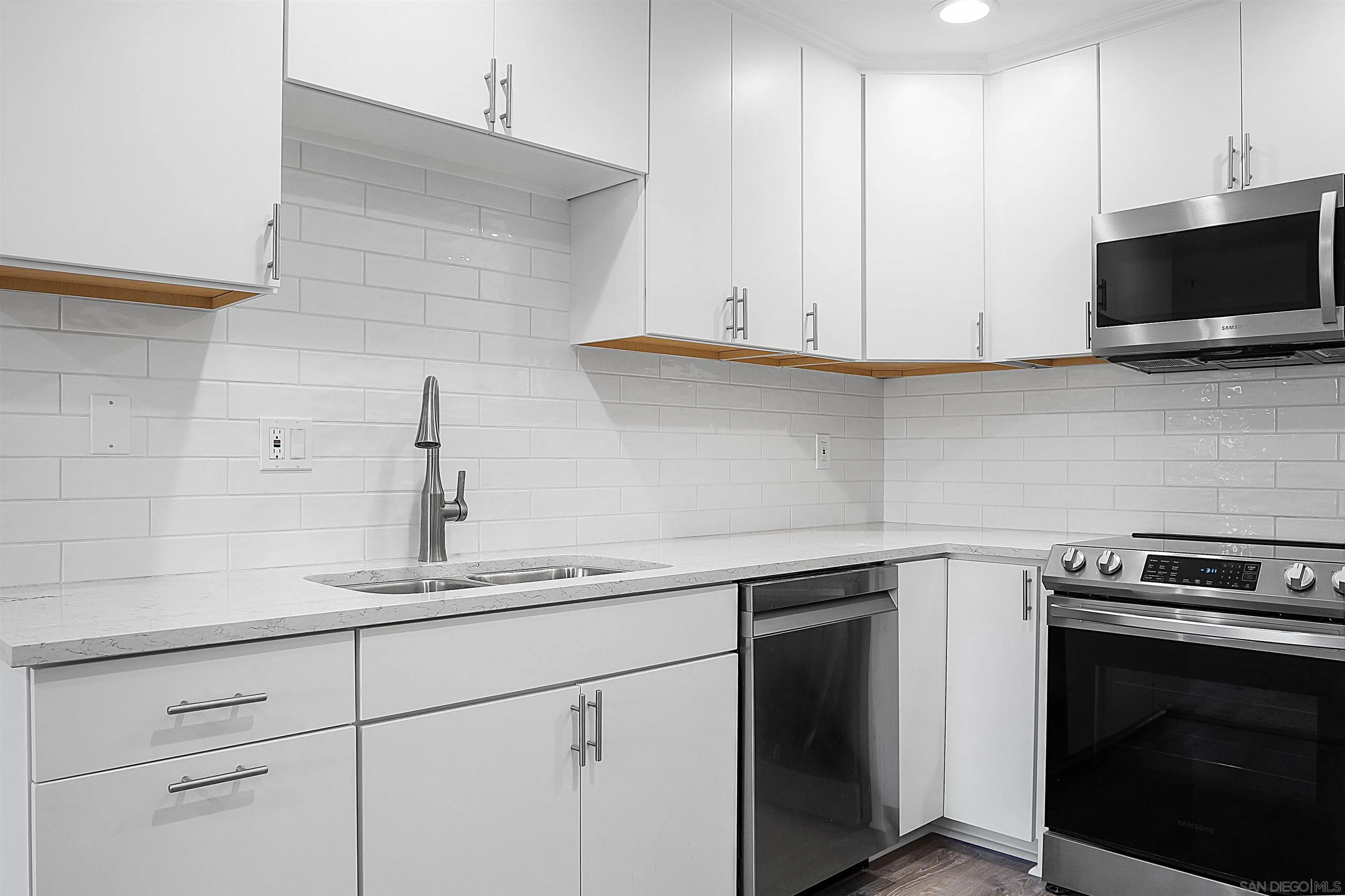 5605 Friars Road, Unit 304 San Diego, CA 92110 - Photo 10 of 37 a kitchen with cabinets stainless steel appliances and a sink